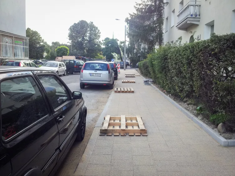 Radni Wrzeszcza Górnego chcą ograniczyć parkowanie samochodów na chodnikach, co jest plagą nie tylko w ich dzielnicy. Na zdjęciu ul. Waryńskiego i palety ograniczające parkowanie na remontowanym chodniku. 