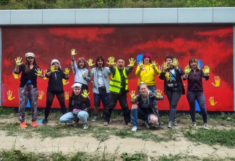 Grupa studentów ASP we Wrocławiu wraz z prof. Adamem Chmielowcem (w środku, w kamizelce) na tle jednego z wykonanych przez siebie murali w ramach akcji "Solidarni z Ukrainą".