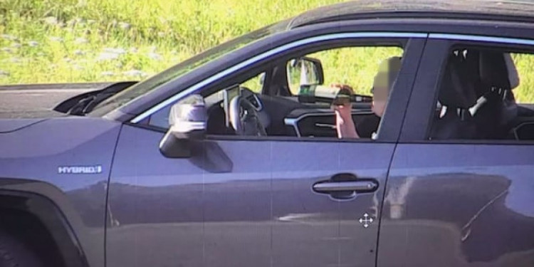 Wykonane przez operatora monitoringu miejskiego zdjęcie, na którym widać, jak kobieta pije za kierownicą whisky.