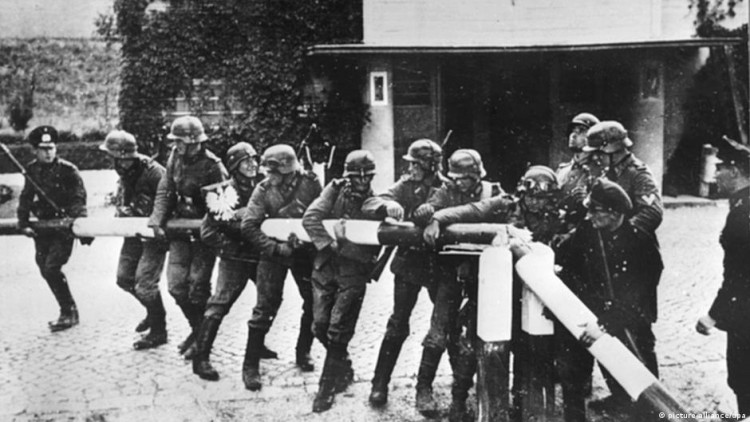 Zainscenizowane zdjęcie przedstawiające rzekomy moment wchodzenia niemieckich wojsk do Polski. W rzeczywistości fotografia została wykonana na punkcie granicznym Kolibki, między Gdynią a należącym do Wolnego Miasta Gdańska Sopotem, prawdopodobnie 1 września 1939 r. Zdjęcie wykonał gdański fotograf Hans Soennke.
