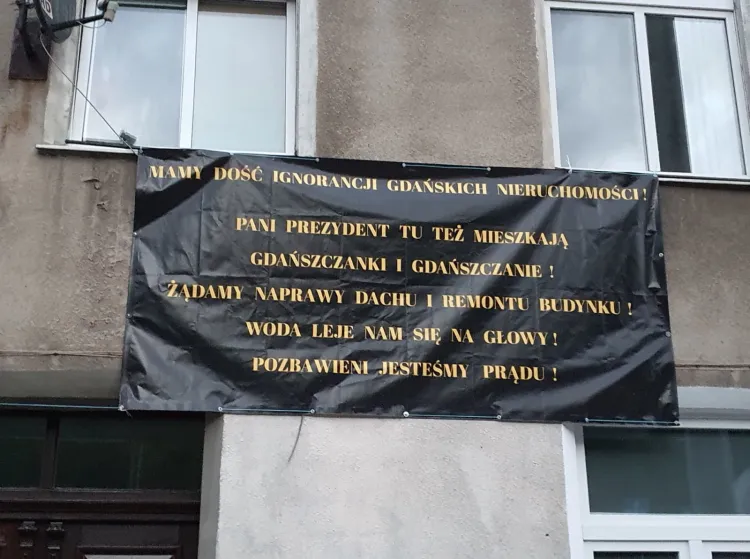 Baner z żądaniem remontu zawisł na jednej z kamienic przy Trakcie św. Wojciecha w Gdańsku.