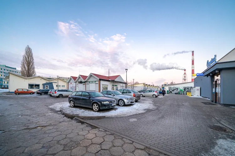 Parking przed sklepem Merkus, gdzie postuluje się wprowadzenie przestrzeni współdzielonej z zachowaniem możliwości postoju aut.