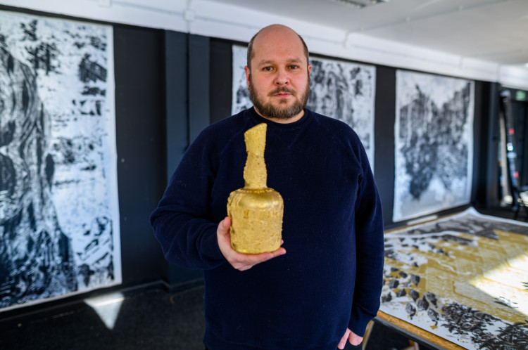 Mariusz Waras z metalowym odlewem zaprojektowanej przez siebie butelki rumu Dictador. Oryginalna butla, cała ze złota, została sprzedana za 1,5 mln dolarów. 