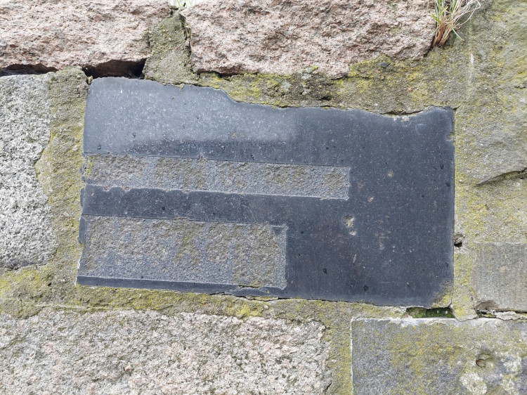 Tablice z czarnego granitu są elementem wypełniającym fragment murku oporowego przy ul. Zakopiańskiej.