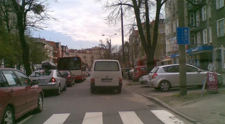 Ulica Dmowskiego okiem kierowcy osobówki. Na lewym pasie stoi autobus, buspas jest na prawym...