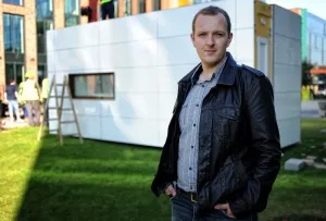 Krzysztof Droszcz z pracowni Rebel Concept przed pokazowym budynkiem modułowym, który stanął przed siedzibą Gdańskiego Inkubatora Przedsiębiorczości Stater.